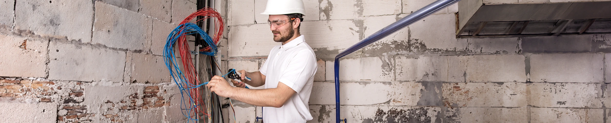 An electrician running new cable into a wall box during a rewire